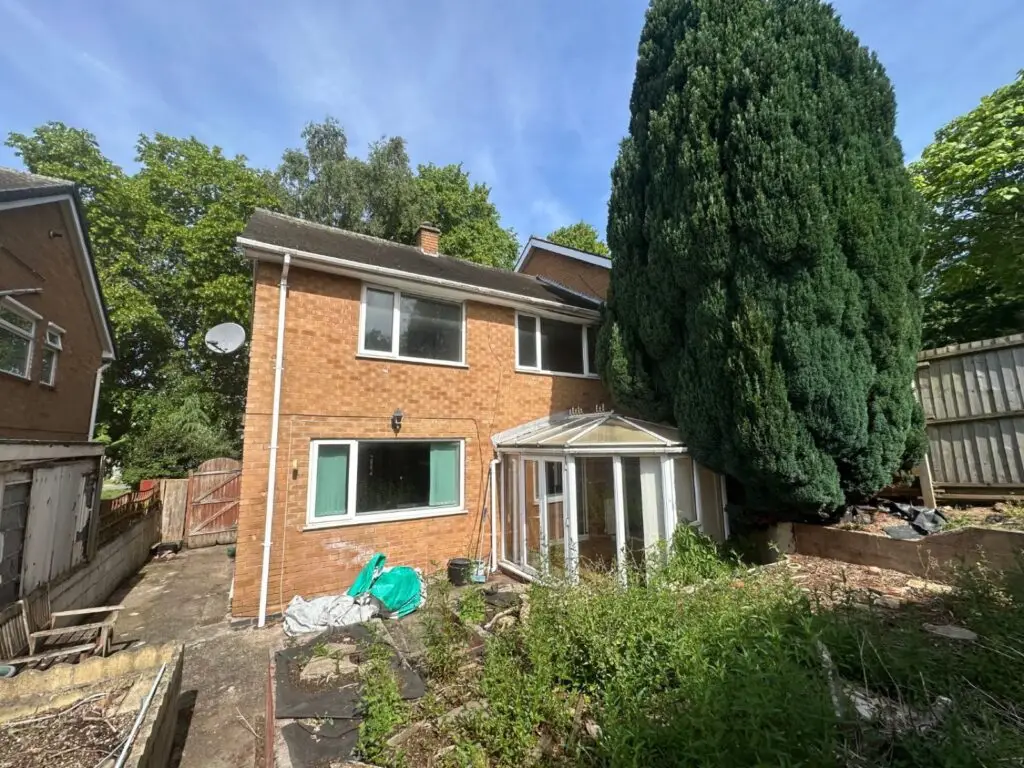 Rear of a Gedling rental property before refurbishment, with an overgrown garden and old shed