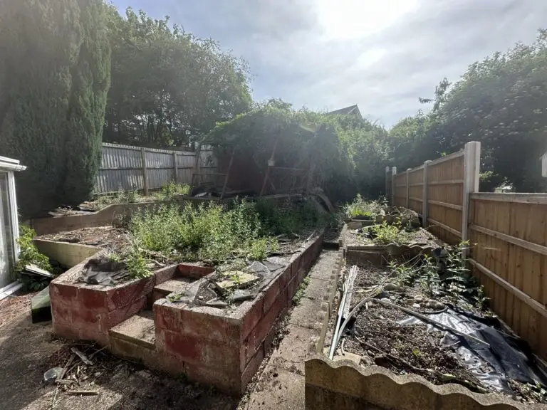 Overgrown back garden with crumbling raised beds before the Gedling refurbishment