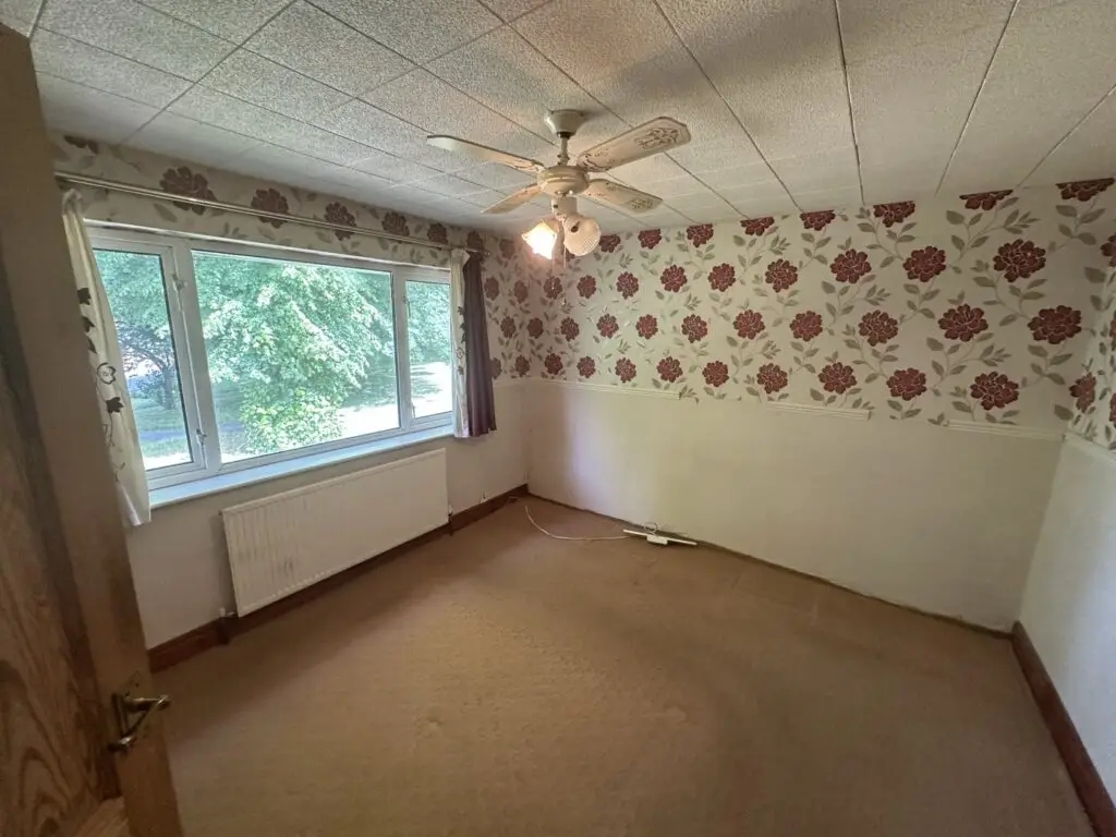 Bedroom with old wallpaper and ceiling tiles before the refurbishment