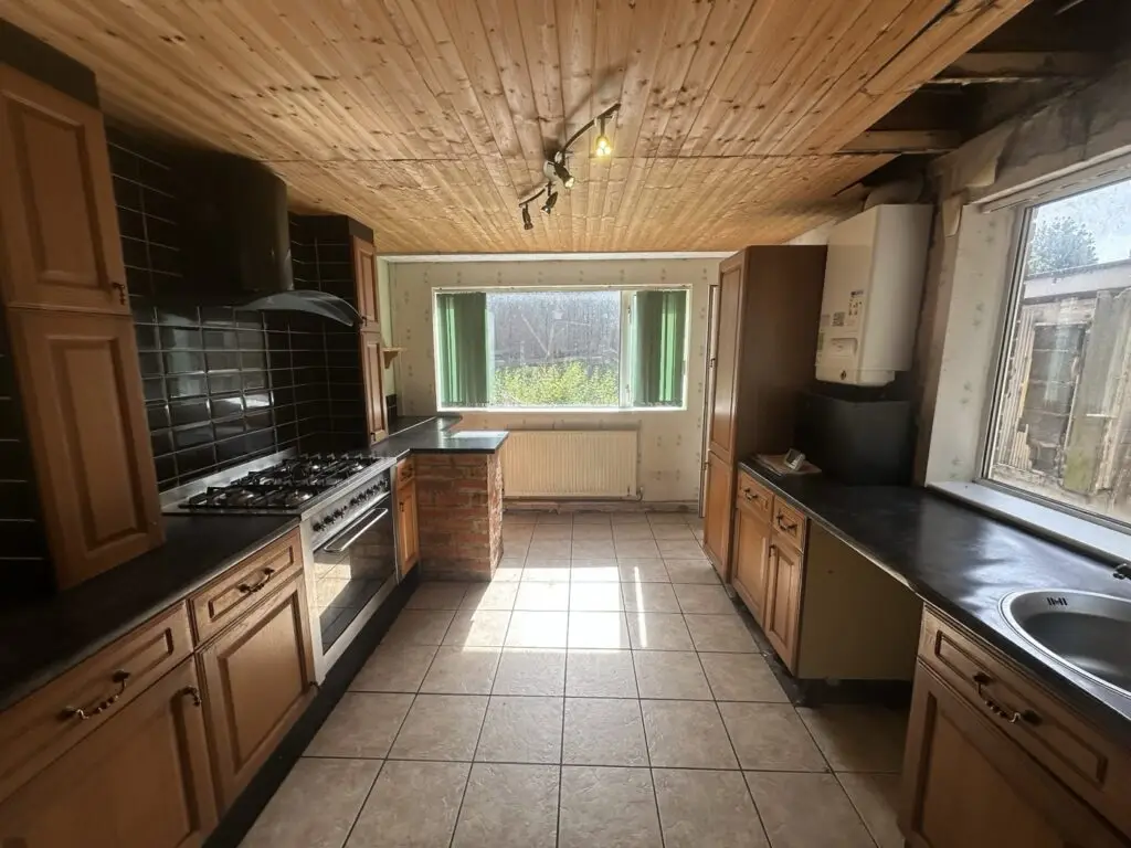 Dated kitchen with wood-clad ceiling and old units before the Gedling refurbishment