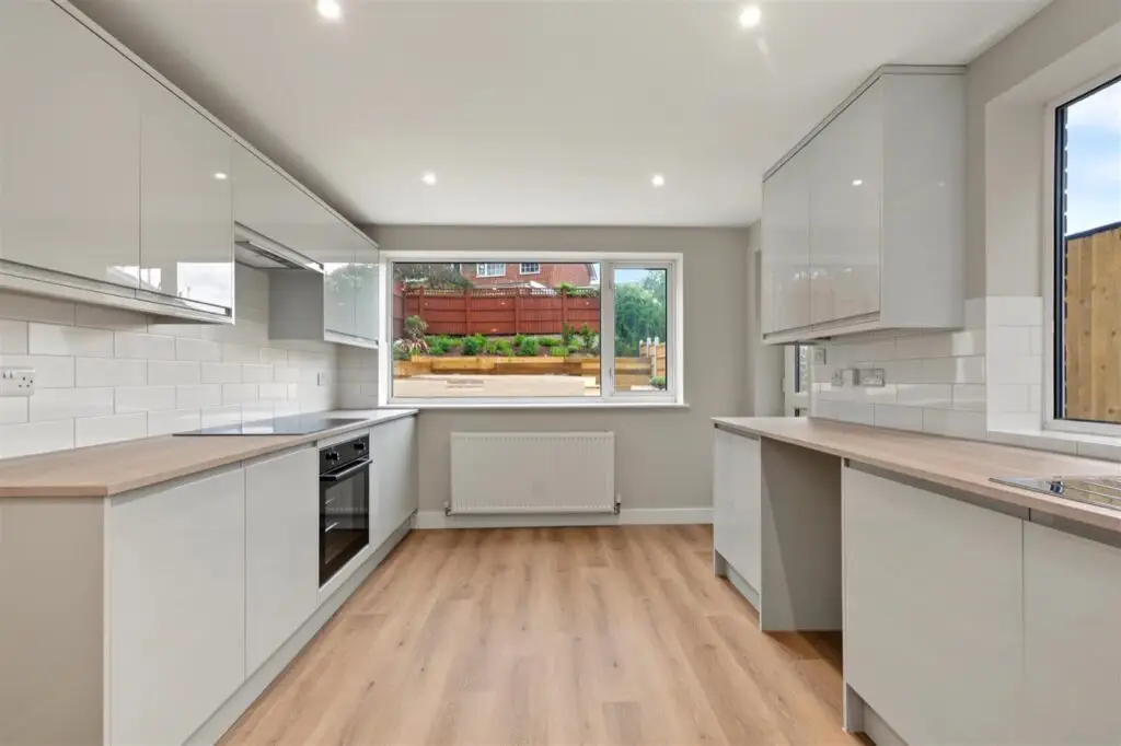 New fitted kitchen with grey gloss units and wood-effect flooring in the refurbished Gedling property